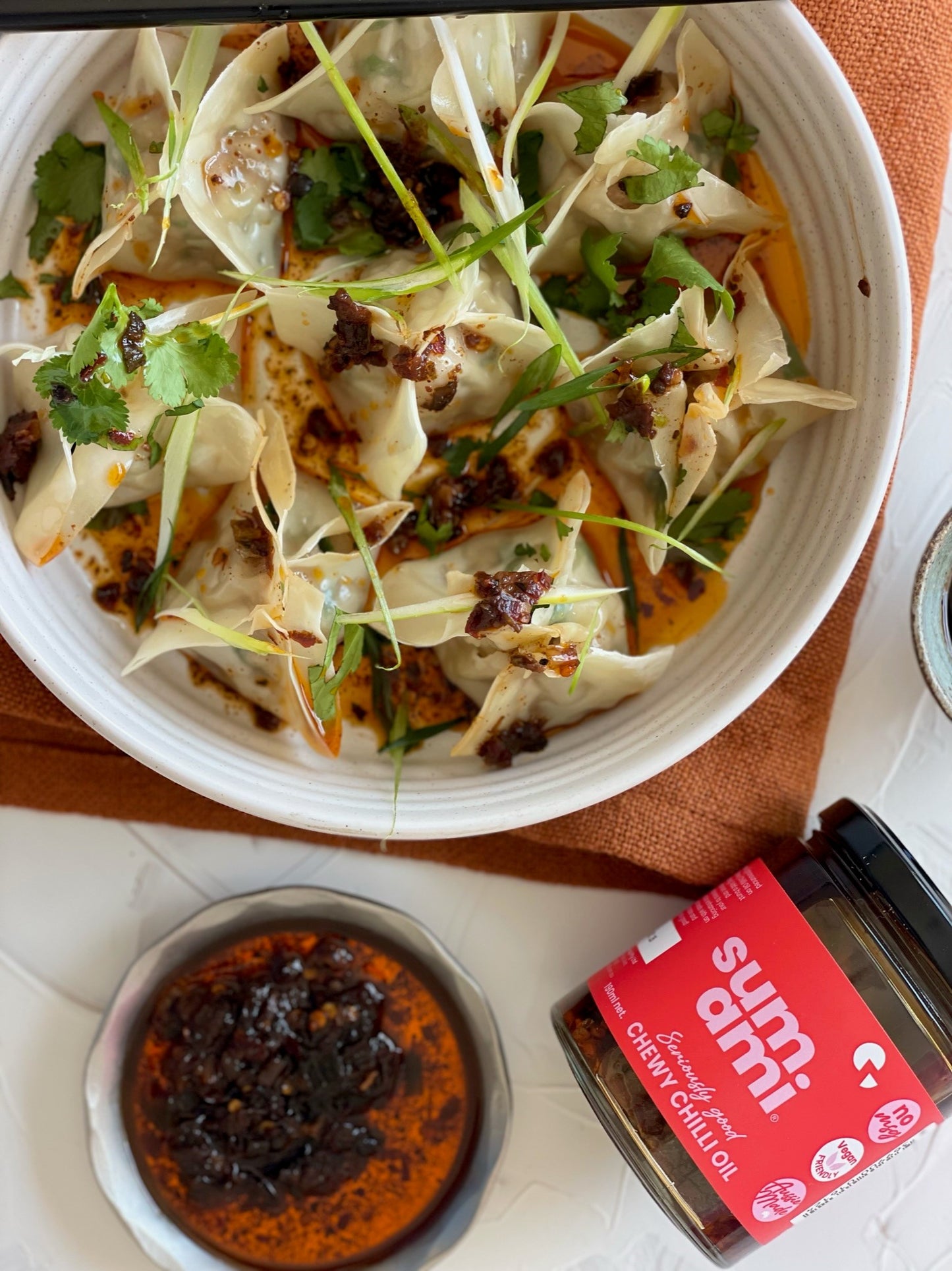 Sumami Chewy Chilli Oil drizzled over delicious dumplings, showcasing its rich texture and vibrant color, perfect for enhancing your meals.
