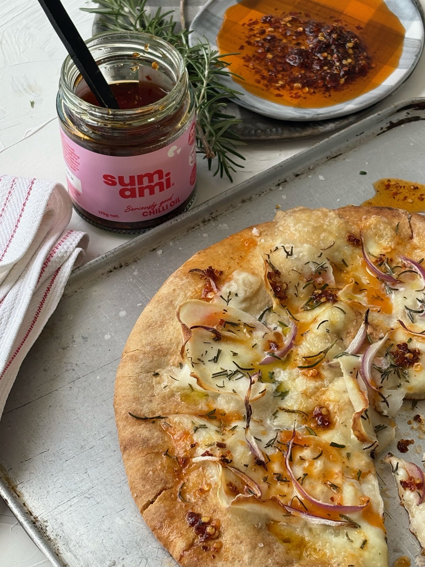 Sumami Original Chilli Oil drizzled over a freshly baked pizza, highlighting its vibrant color and spices, perfect for adding a burst of flavor to your favorite slices.
